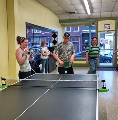 Kids playing ping pong at the CrossWord Cafe